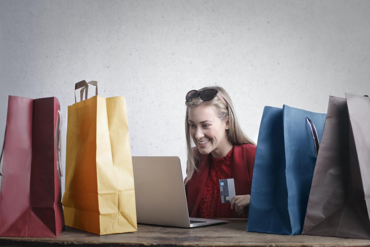 Imagem de uma mulher olhando a tela do computador fazendo compras online