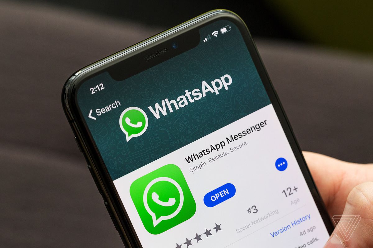 Imagem de uma pessoa segurando o celualar com o app do WhatsApp na tela