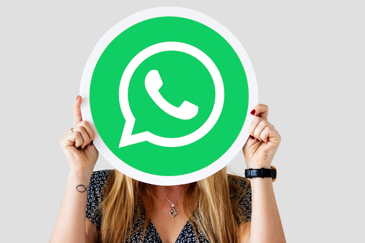 Vendas pelo WhatsApp: A imagem mostra uma mulher segurando o símbolo do WhatsApp